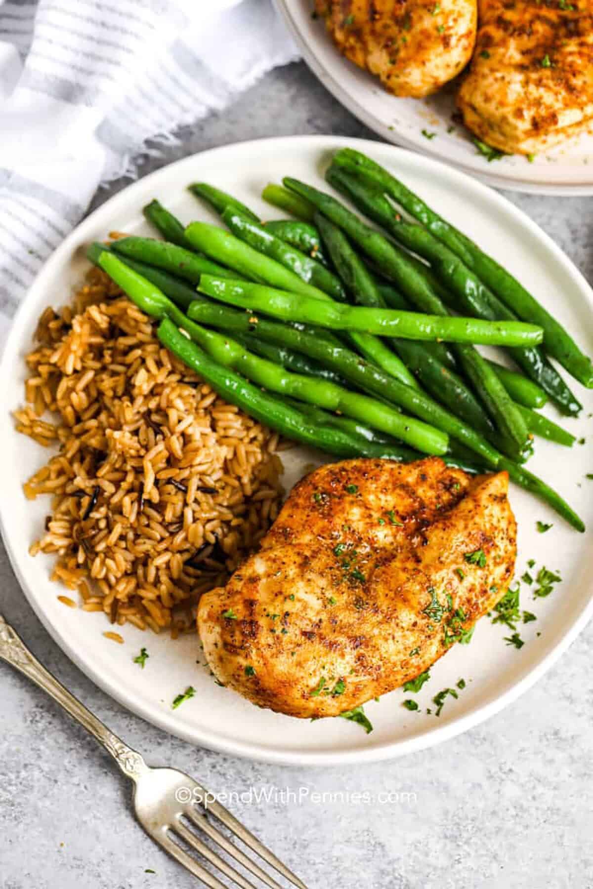 Air Fryer Chicken Breasts on a plate with rice and beans